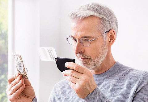 Man with Low Vision using reading aid.